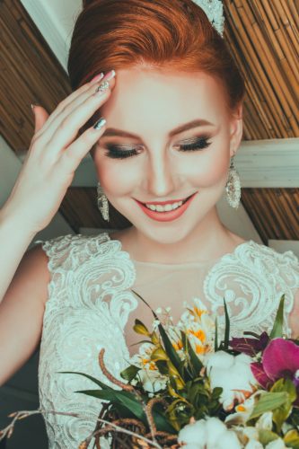 Smiling bride with red hair and smoky eye makeup